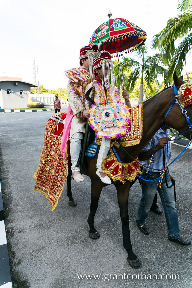 punjabi indian groom arriving by horse at his wedding